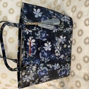 Elegant tote with cute tassels. Nice pouch in back for phone.